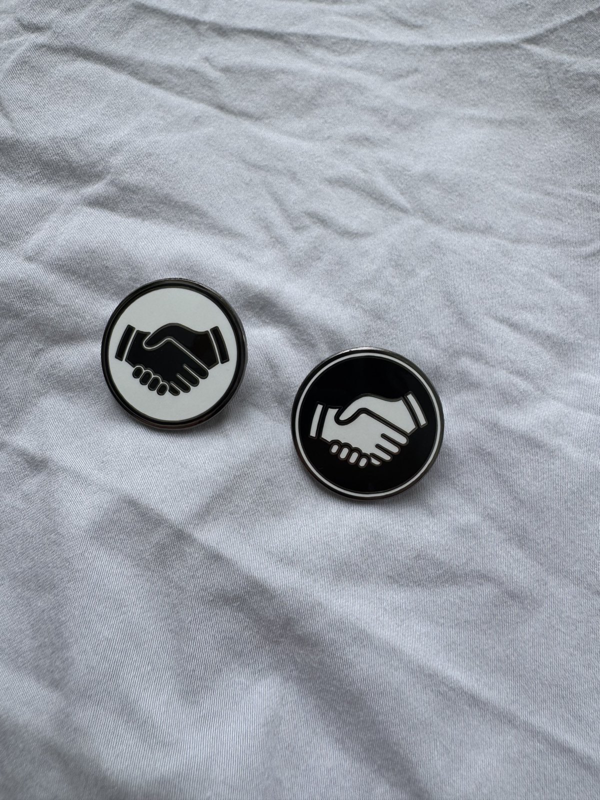 A white and a black Mates pin together