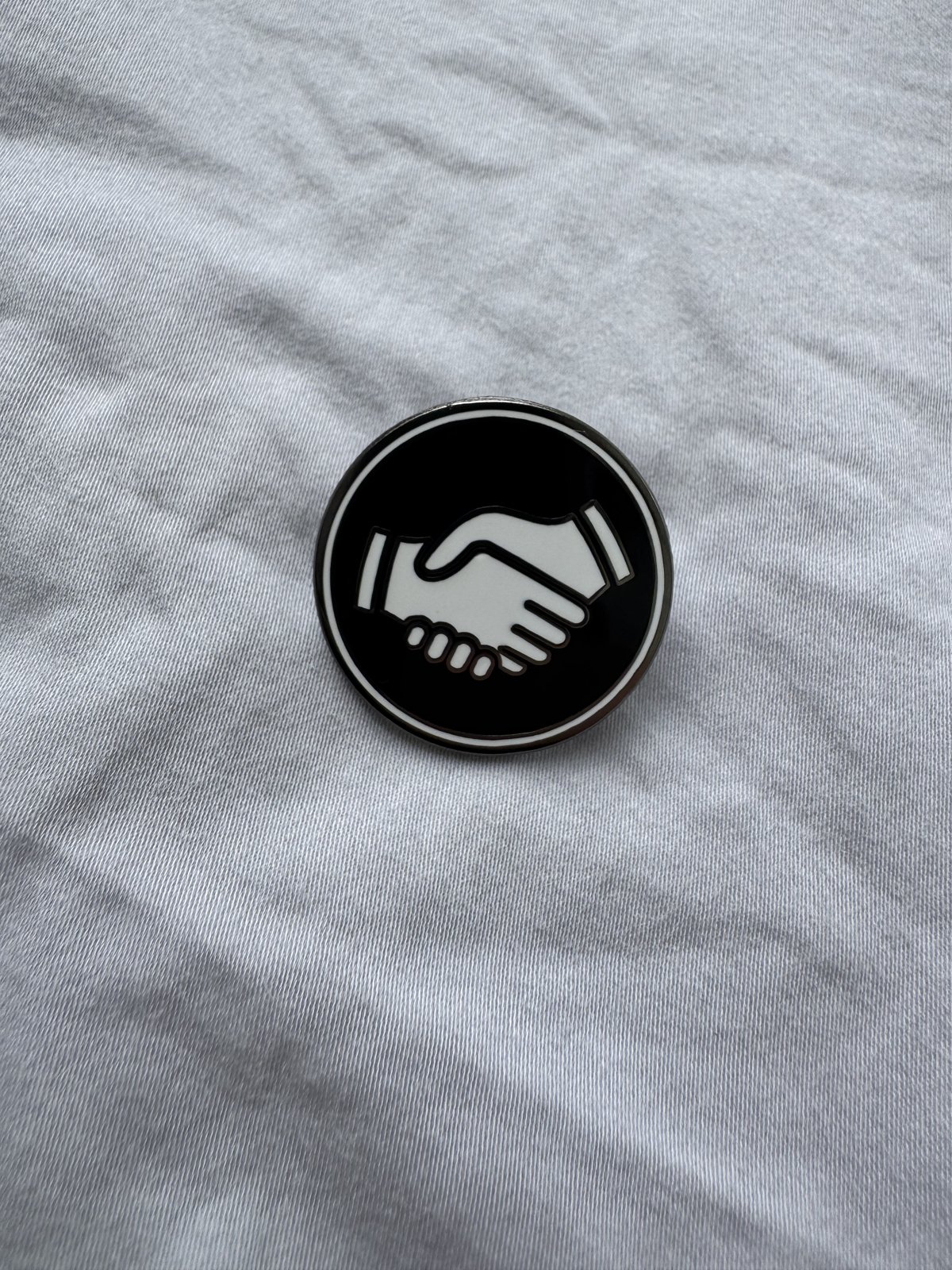 The black Mates pin on white linen