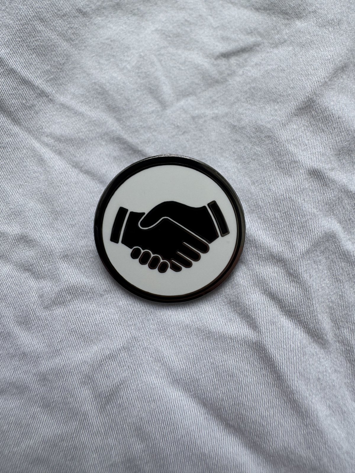 The white Mates pin on white linen